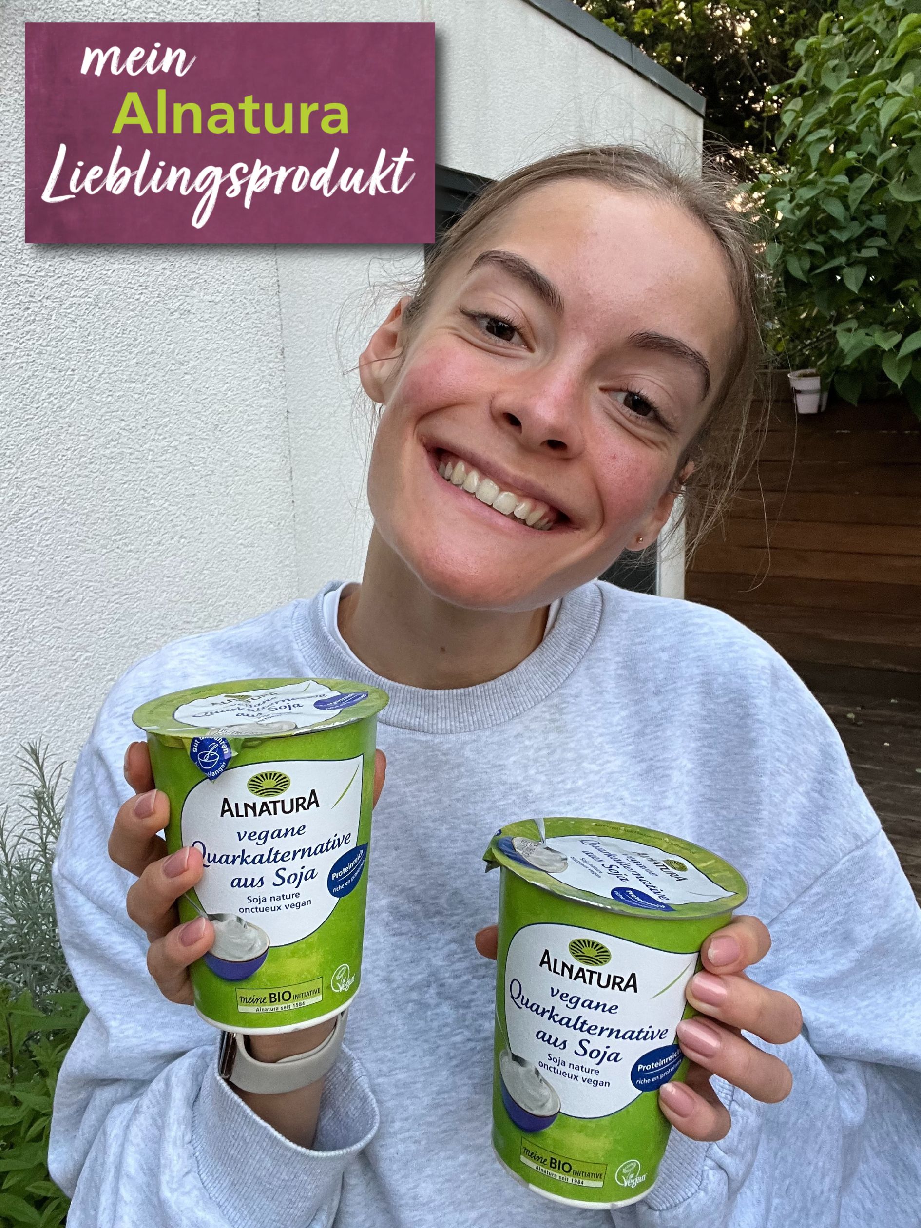 Alnatura Kundin Lisa hält ihr Alnatura Lieblingsprodukt vegane Quarkalternative aus Soja in die Kamera.