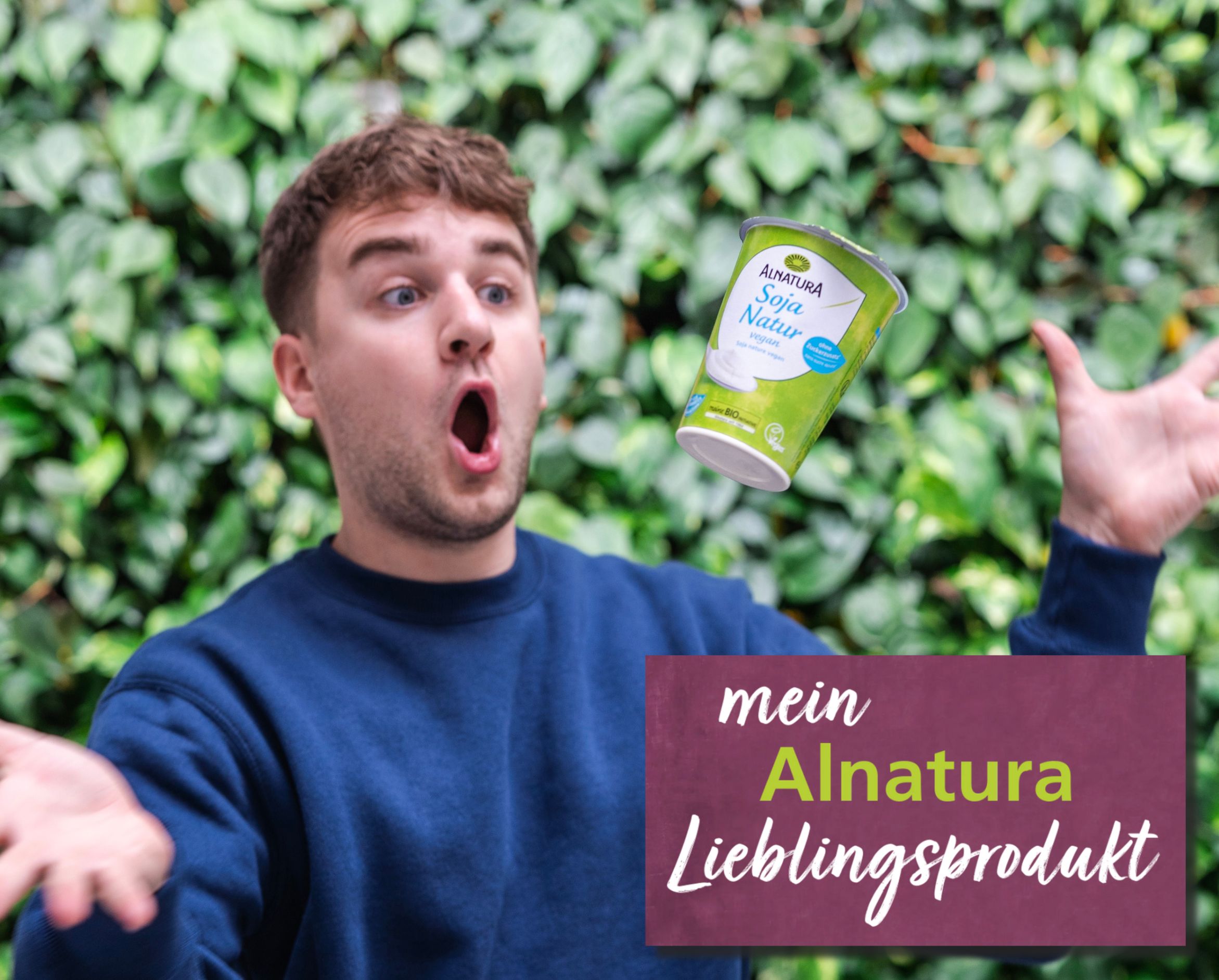 Alnatura Kunde Paul schaut fasziniert sein Alnatura Lieblingsprodukt Soja Natur vegan an, das vor ihm in der Luft zu schweben scheint.