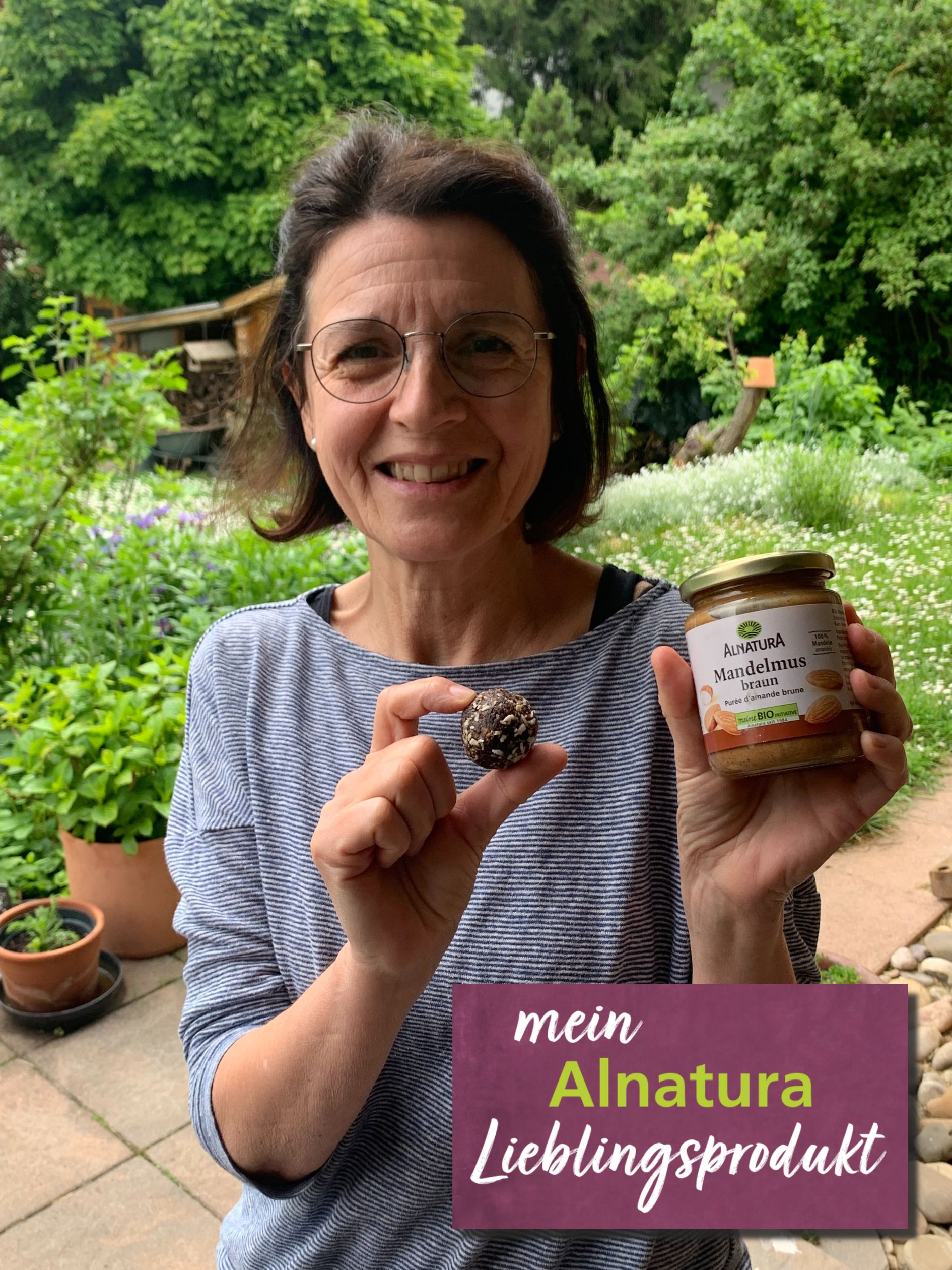 Alnatura Kundin Sabine hält ihr Alnatura Lieblingsprodukt Mandelmus braun in die Kamera.