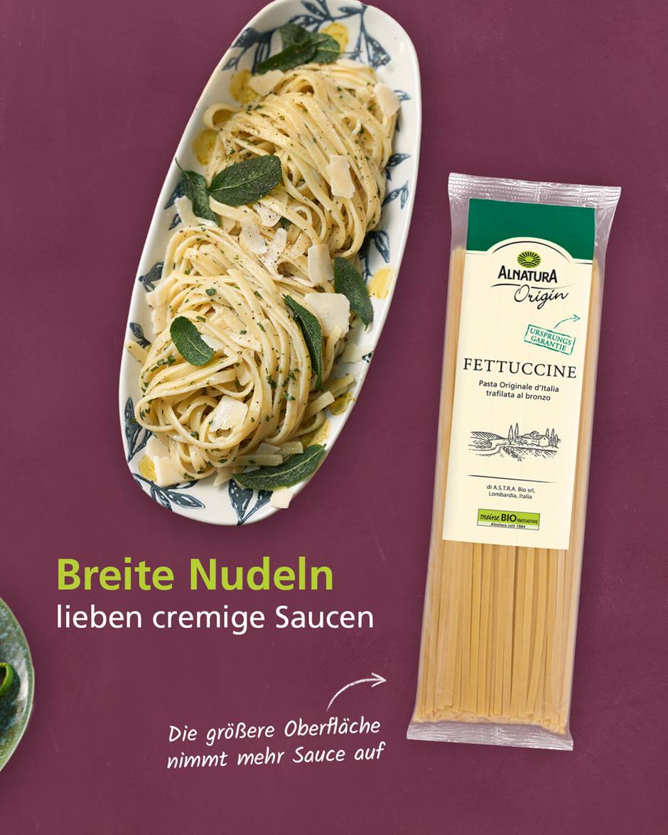 Es ist eine Packung Alnatura Origin Fettuccine und ein Teller mit zubereiteten Fettuccine garniert mit Parmesan und Minzblättern zu sehen. Die Überschrift sagt "Breite Nudeln lieben cremigen Saucen" und ein Infotext "Die größere Oberfläche nimmt mehr Sauce auf"