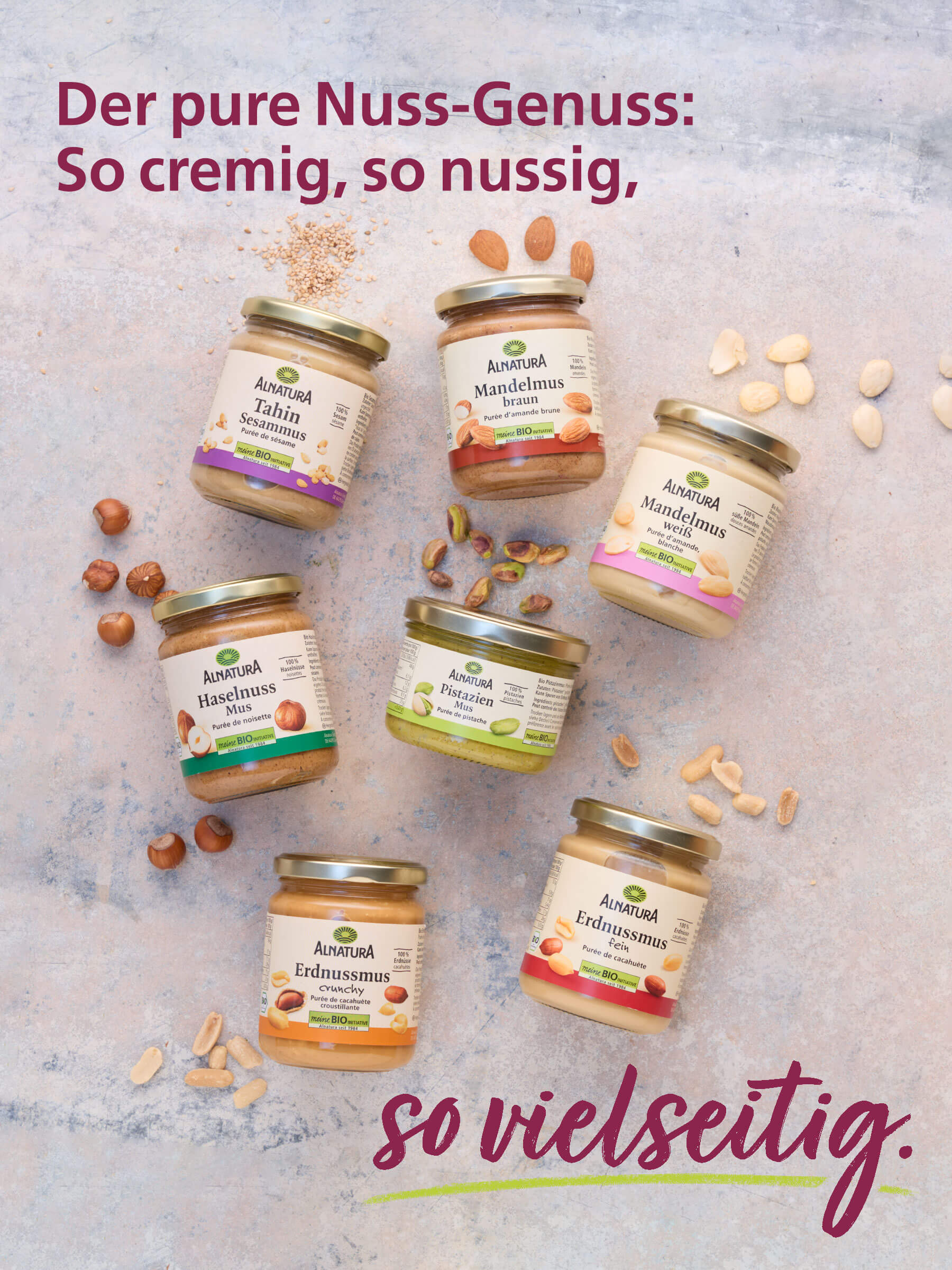 Sieben Gläser Alnatura Nuss-Muse liegen auf einem hellen Untergrund: Tahin, Mandelmus braun, Mandelmus weiß, Haselnuss-Mus, Pistazien-Mus, Erdnussmus fein und Erdnussmus crunchy. Dazu der Text: "Der pure Nuss-Genuss: So cremig, so nussig, so vielseitig."