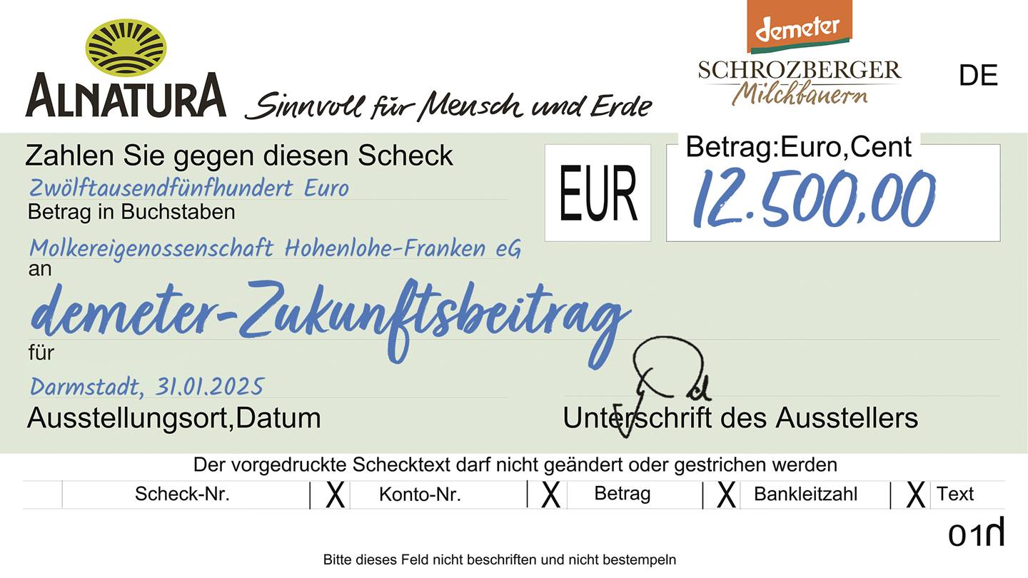 Darstellung eines Spendenschecks "demeter-Zukunftsbeitrag" von Alnatura an die Molkereigenossenschaft Hohenlohe-Franken eG in Höhe von 12500 Euro.