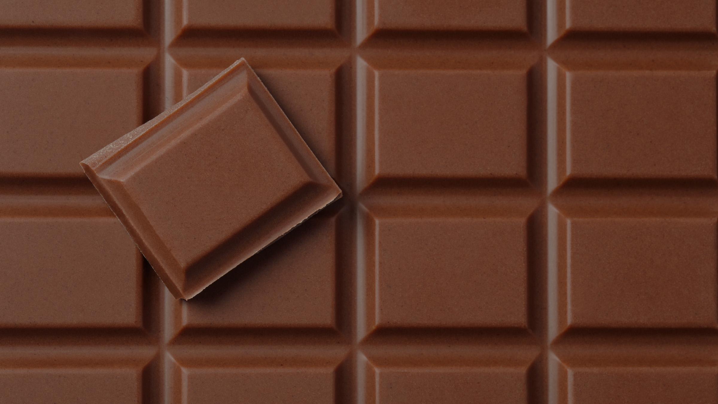 Tafel Schokolade mit einem einzelnen Stück Schokolade obendrauf.