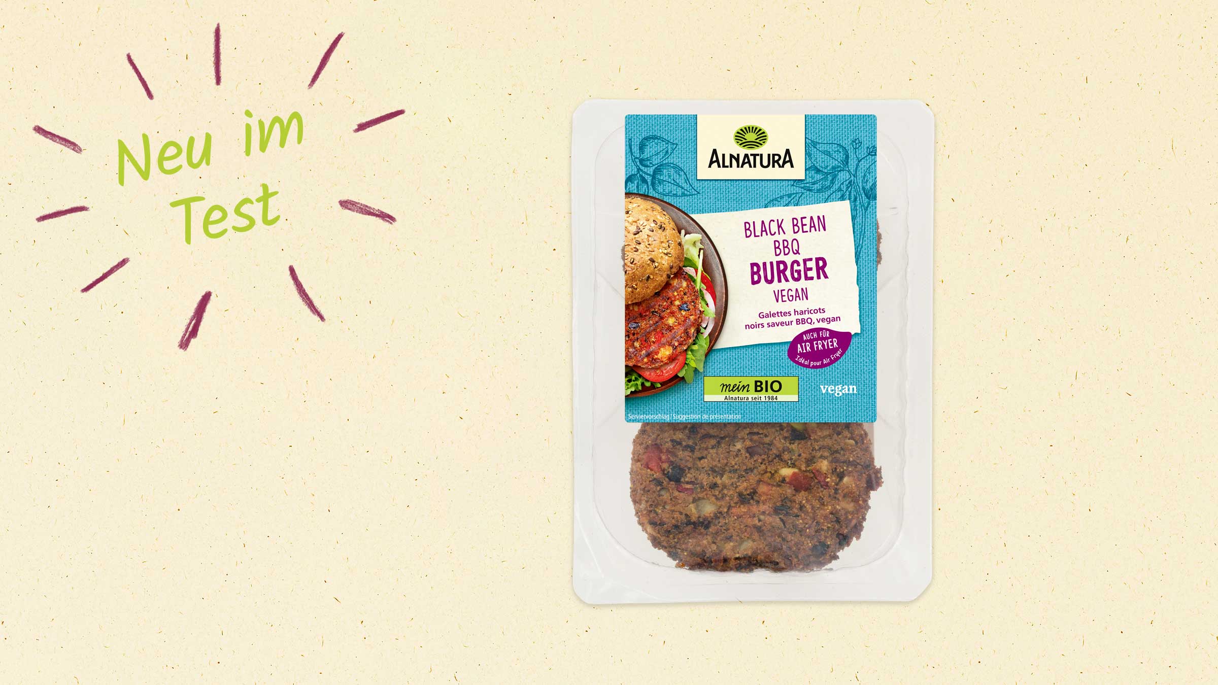 Ein Alnatura Black Bean BBQ Burger vegan in einer Plastikverpackung, mit einem Bild eines Burger-Sandwiches und dem Burger-Patty darauf. Links im Bild steht "Neu im Test".