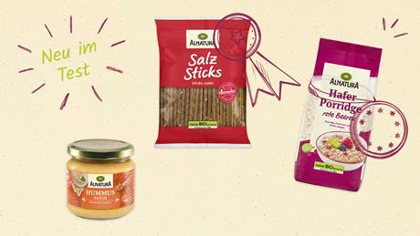 Das Bild zeigt drei Alnatura-Produkte: Hummus Natur, Salzstangen und Hafer Porridge rote Beeren, mit dem Text "Neu im Test".
