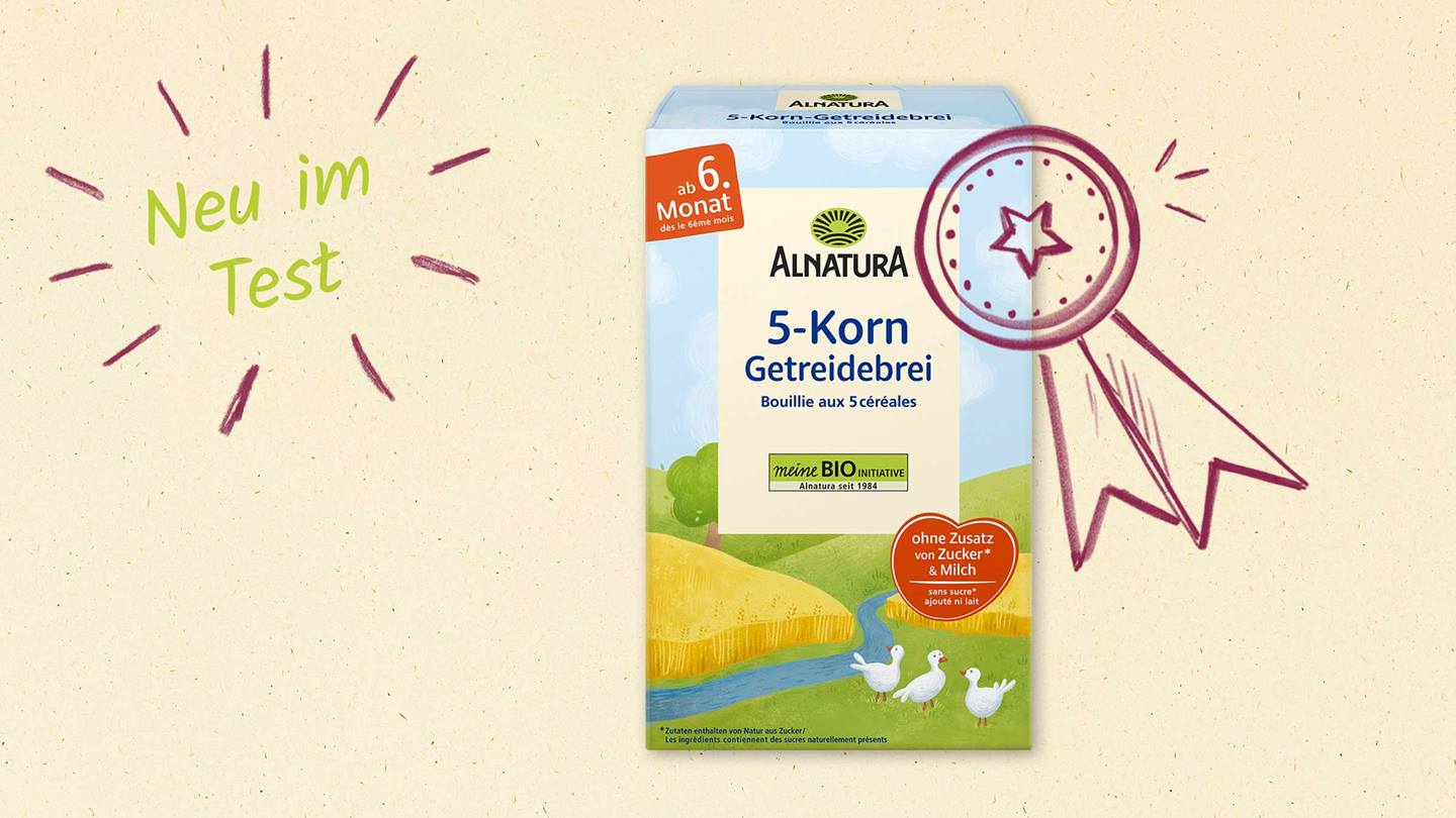 Das Bild zeigt eine Packung Alnatura 5-Korn-Getreidebrei für Babys ab dem 6. Monat. Die Packung ist in hellen Farben gestaltet und zeigt eine idyllische Landschaft mit einem Fluss und Gänsen. Ein handgezeichneter Preis krönt die Packung und der Text „Neu im Test“ deutet auf eine Produktbewertung hin. Die Hervorhebung „ohne Zusatz von Zucker & Milch“ betont die natürlichen Inhaltsstoffe.