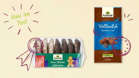 Das Bild zeigt eine Packung "Alnatura Feine Oblaten Lebkuchen" und eine Tafel "Alnatura Vollmilch Schokolade". Die Lebkuchen sind in einer durchsichtigen Plastikverpackung mit einem farbenfrohen Etikett, das ein Lebkuchenmännchen und Geschenke zeigt. Die Schokolade befindet sich in einer blauen Verpackung, auf der ein Bild von Schokoladenstücken abgebildet ist. Oben links steht "Neu im Test" und beide Produkte haben eine Art Siegel.