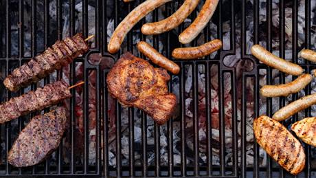 Verschiedene Fleischsorten liegen auf dem Grill