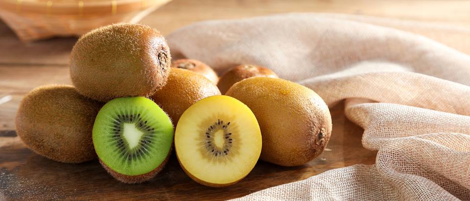 Kiwis ganz und aufgeschnitten liegend