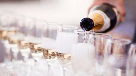 Schaumwein wird in Sektgläser gefüllt