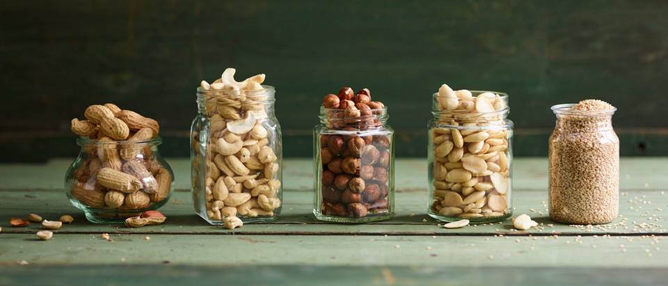verschiedene Nüsse in Gläsern: Erdnüsse, Cashewkerne, Mandeln, Haselnüsse
