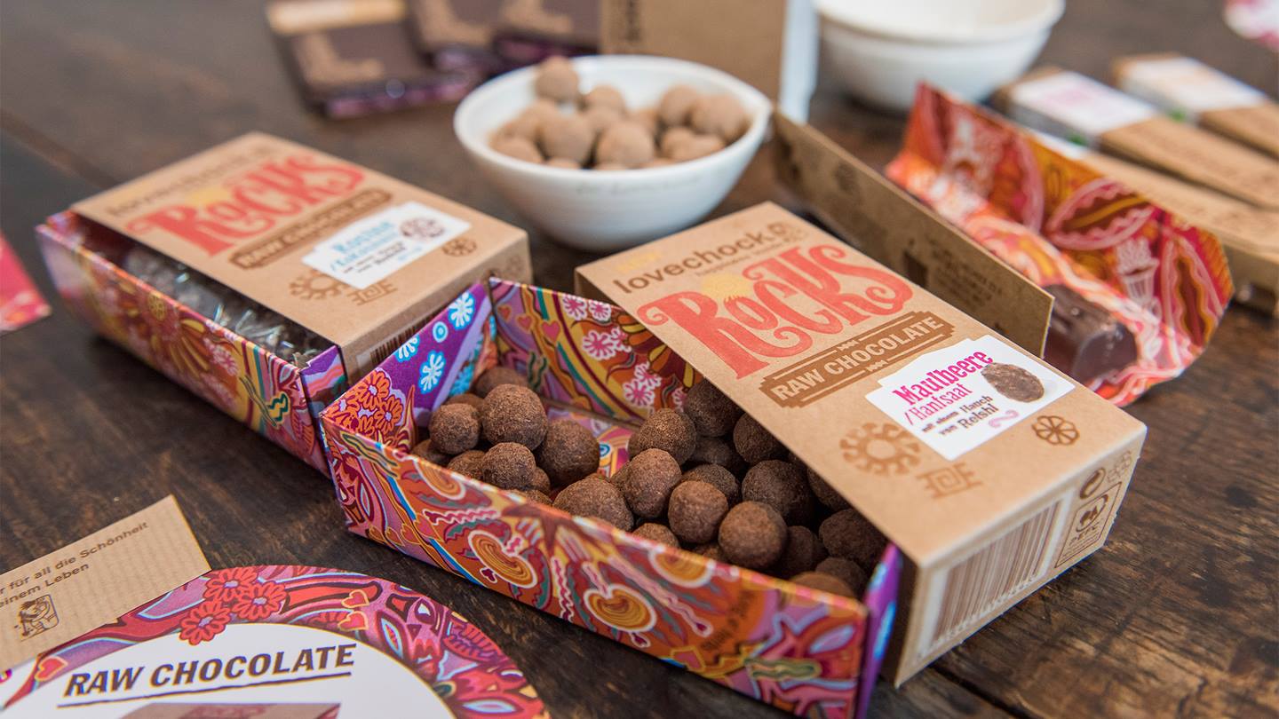 Verschiedene Lovechock Produkte, im Vordergrund die Lovechock Rocks Kugeln Maulbeere/ Hanfsaat