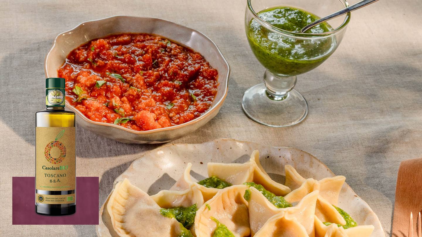 Teller mit gefüllten Teigtaschen und grünem Pesto daneben in einer Glasschale sowie eine Schale mit roter Tomatensauce