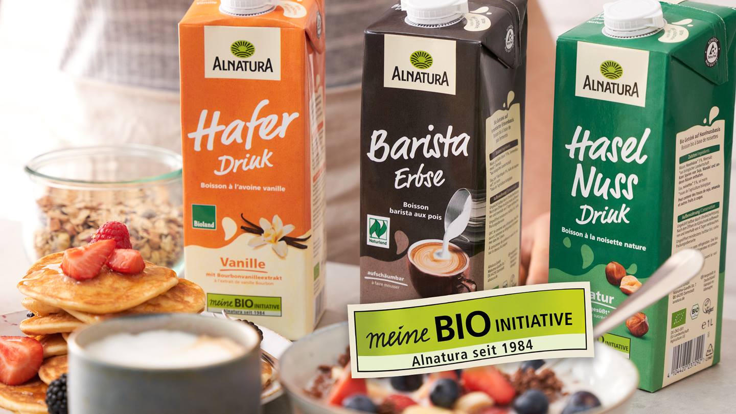 Grünes Feld mit Beschriftung "Meine Bio-Initiative - Alnatura seit 1984" mit drei Alnatura Produkten