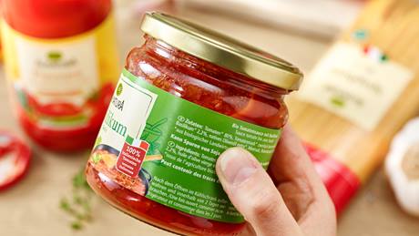 Hand, die eine Alnatura Tomatensauce hält, zu sehen ist die Zutatenliste