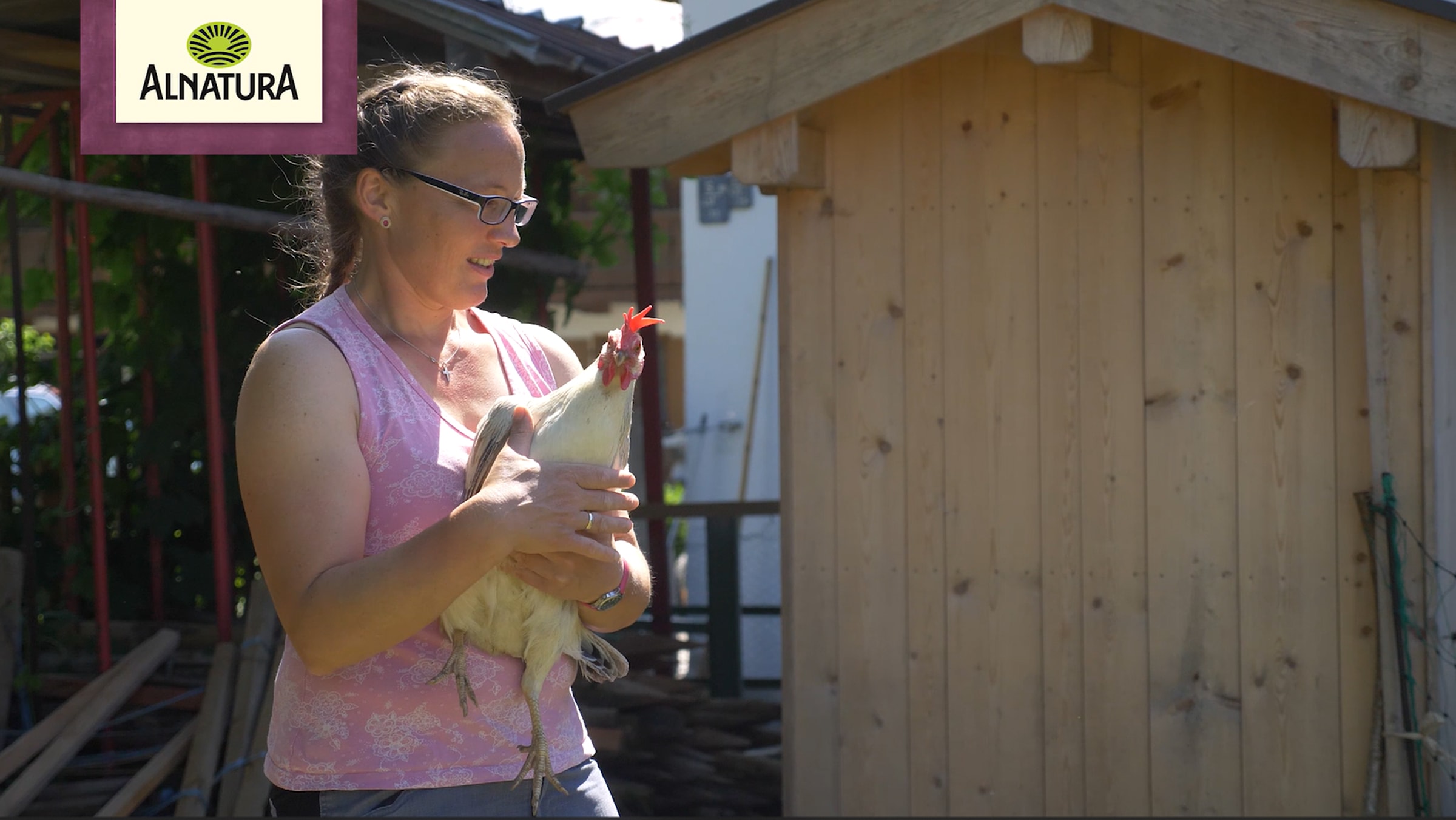 Alnatura Bio-Bauern-Initiative: Landwirtin hält ein Huhn in den Händen