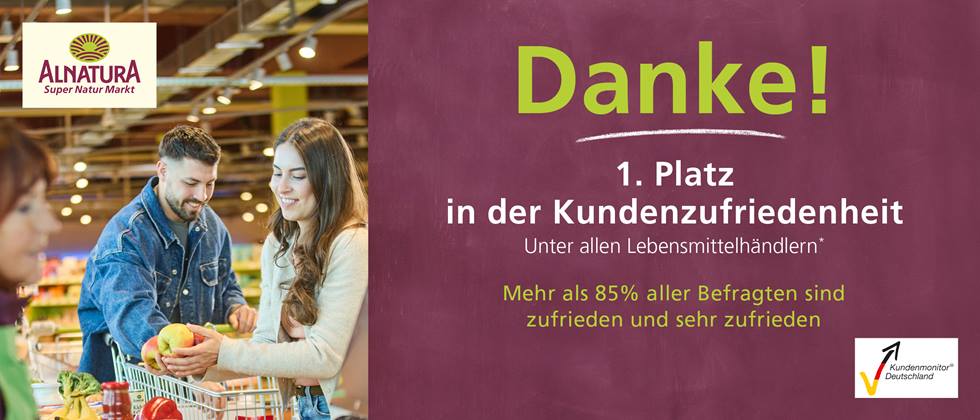 Werbetafel zum Abschneiden der Alnatura Super Natur Märkte beim Kundenmonitor Deutschland 2026. Links ist eine Einkaufssituation mit 3 Personen zu sehen, rechts steht der Text "Danke! 1. Platz in der Kundenzufriedenheit unter allen Lebensmittelhändlern. Mehr als 85% aller Befragten sind zufrieden und sehr zufrieden."