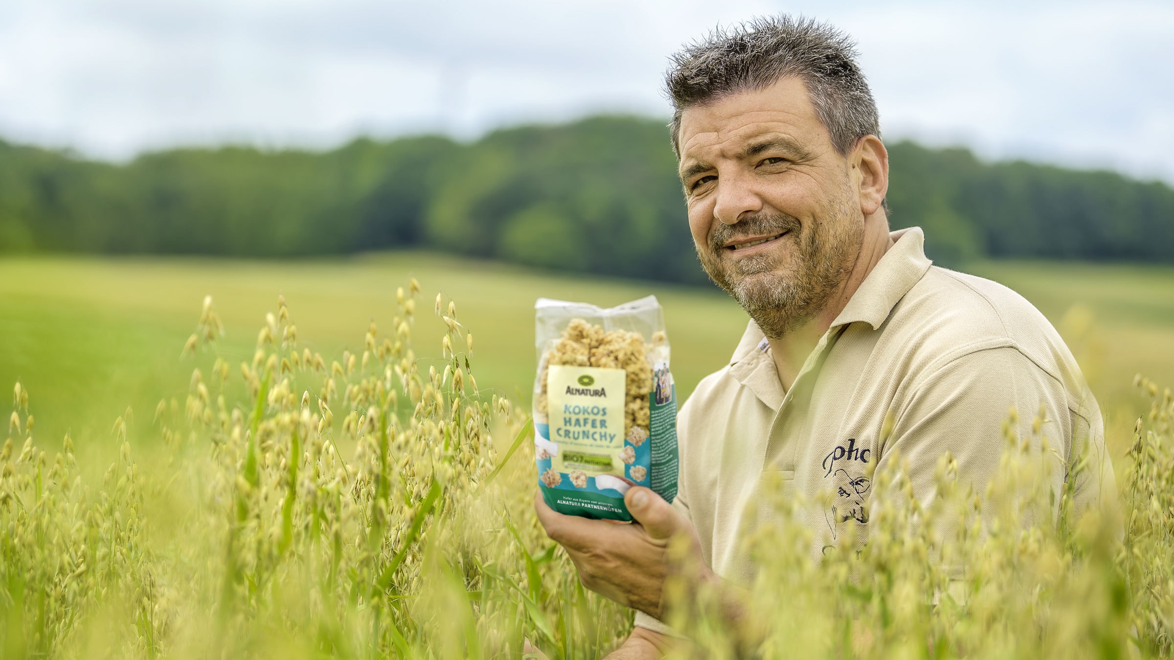 Pierre Ramnick mit dem Alnatura Kokos-Hafer-Crunchy vor dem Haferfeld