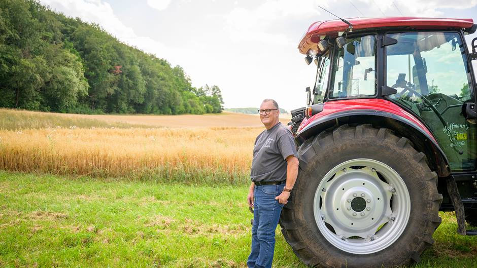 Landwirt Hoffmann vor seinem Haferfeld mit Traktor