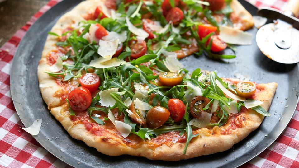 Pizza mit Rucola und Tomaten