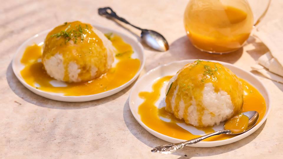 Zwei Teller mit Reisportionen, die mit einer gelben Sauce übergossen sind, daneben ein Glas mit derselben Sauce und ein Löffel