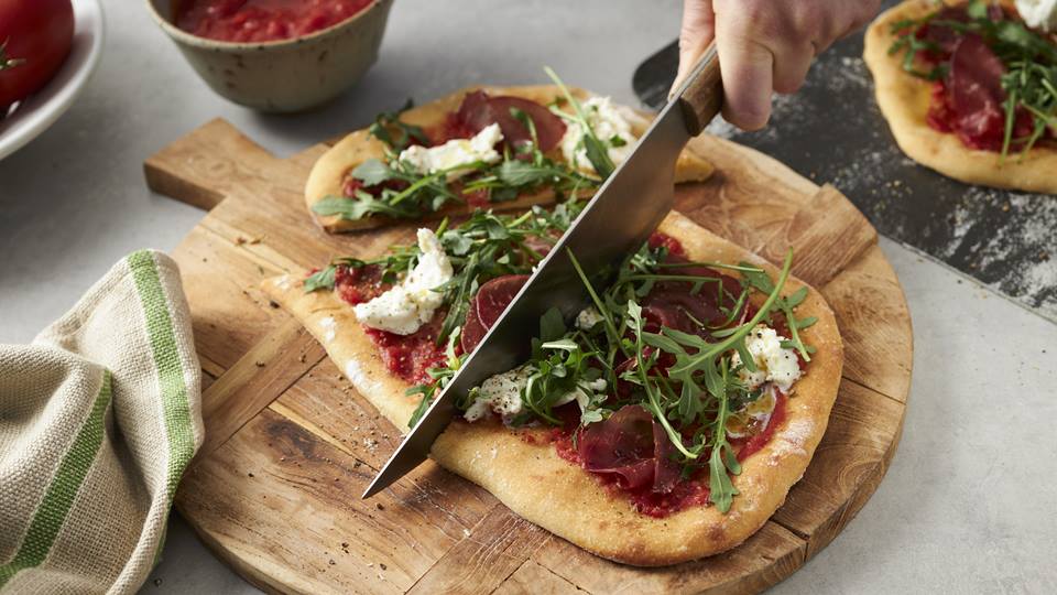 Selbstgemachte Pinsa mit Rucola und Schinken