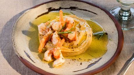 Hummus mit Garnelen serviert mit einem Glas Wasser