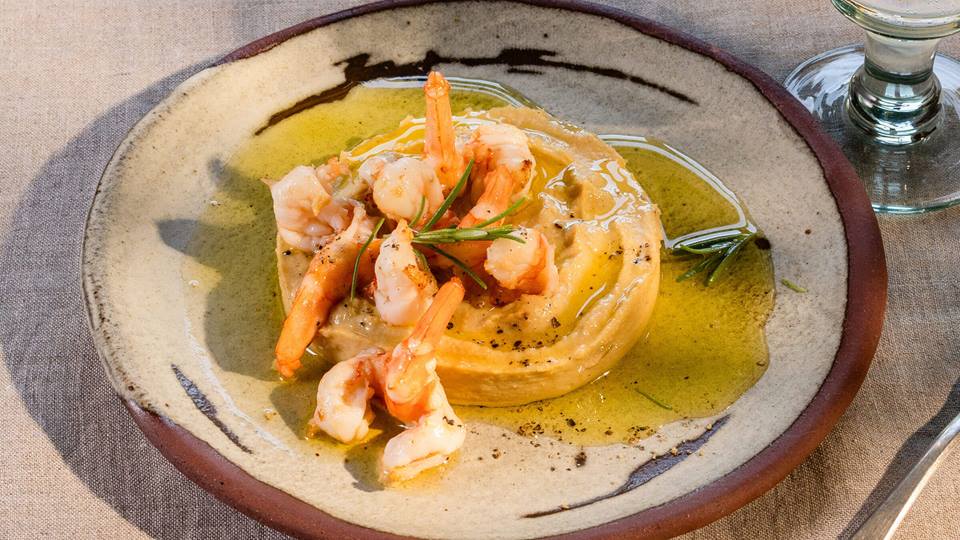 Hummus mit Garnelen serviert mit einem Glas Wasser