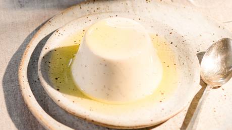 Panna cotta mit Zitronen-Olivenöl auf einem Teller, daneben ein Teelöffel