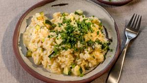 Zucchini-Risotto mit frischen Schnittlauchröllchen, serviert mit einer Gabel