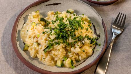 Zucchini-Risotto mit frischen Schnittlauchröllchen, serviert mit einer Gabel