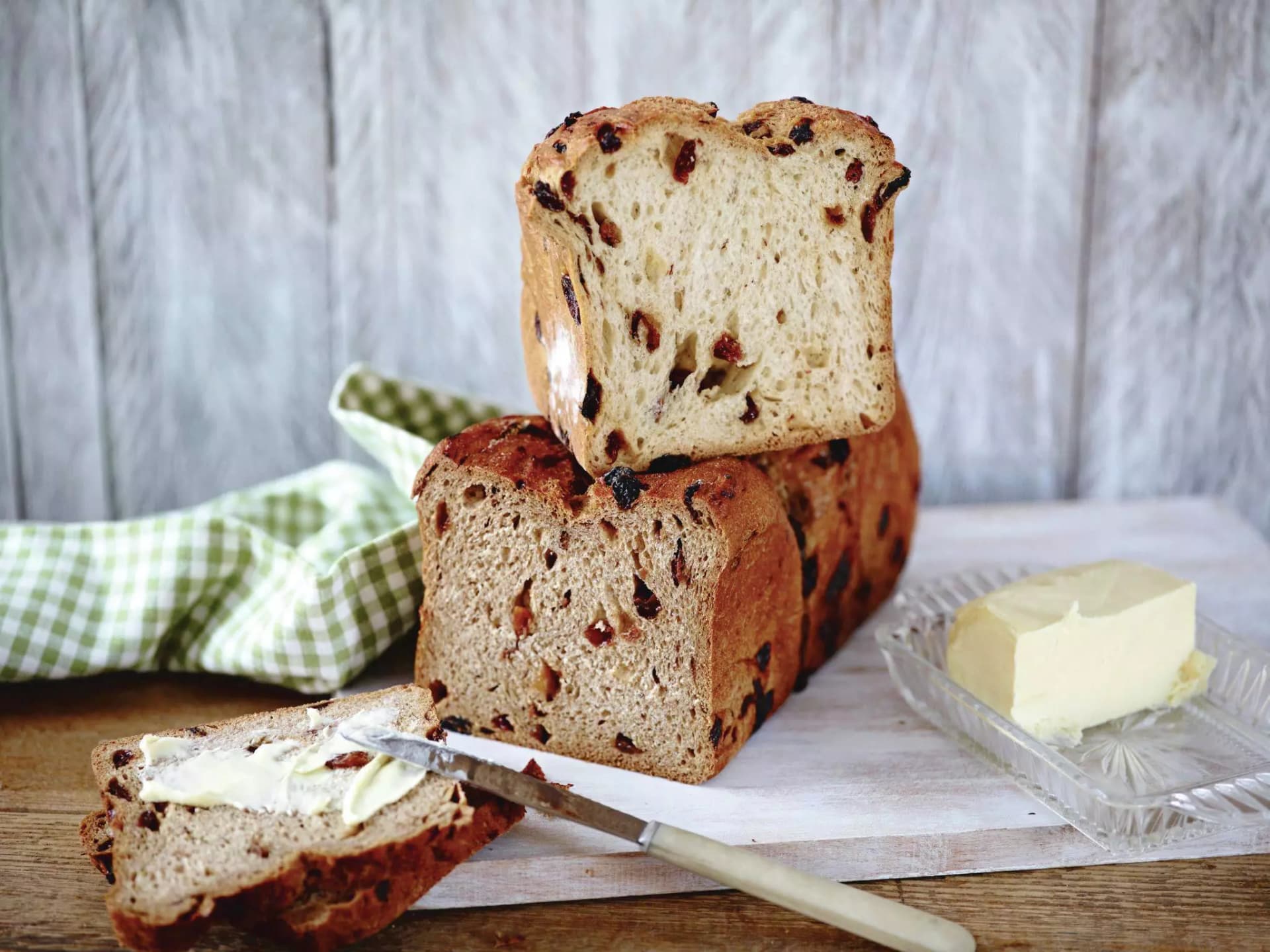 In der Mitte aufgeschnittenes Kastenbrot. Eine Scheibe ist mit Butter bestrichen.
