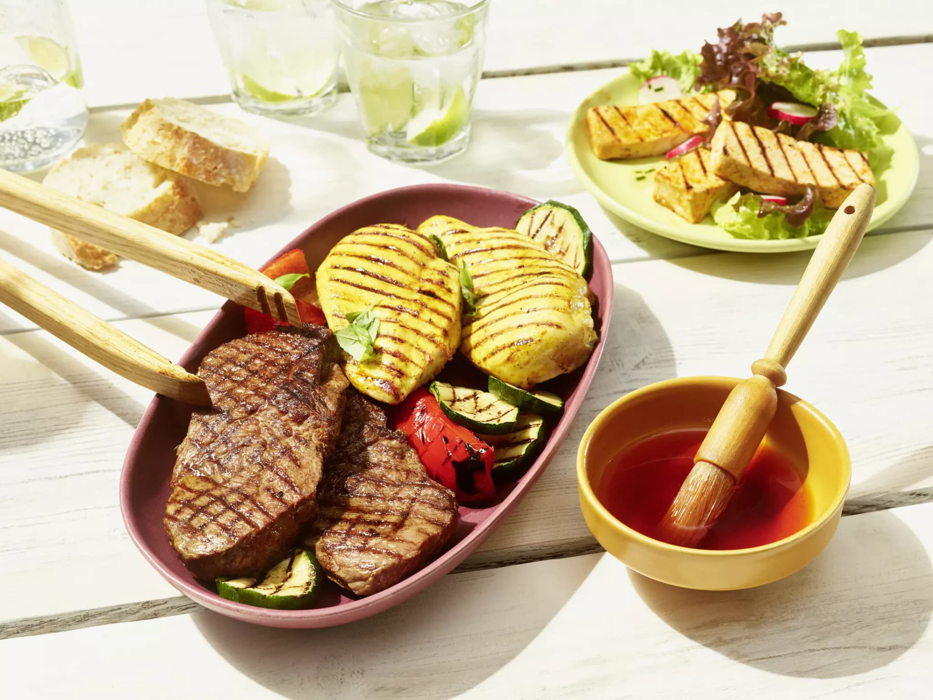 Schale mit gegrilltem Fleisch und Gemüse, daneben Grillmarinade aus Paprika und Chili