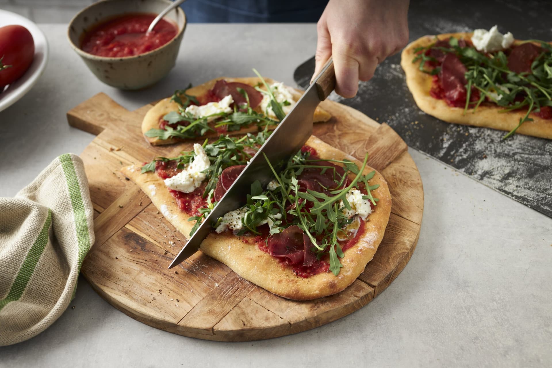 Selbstgemachte Pinsa mit Rucola und Schinken