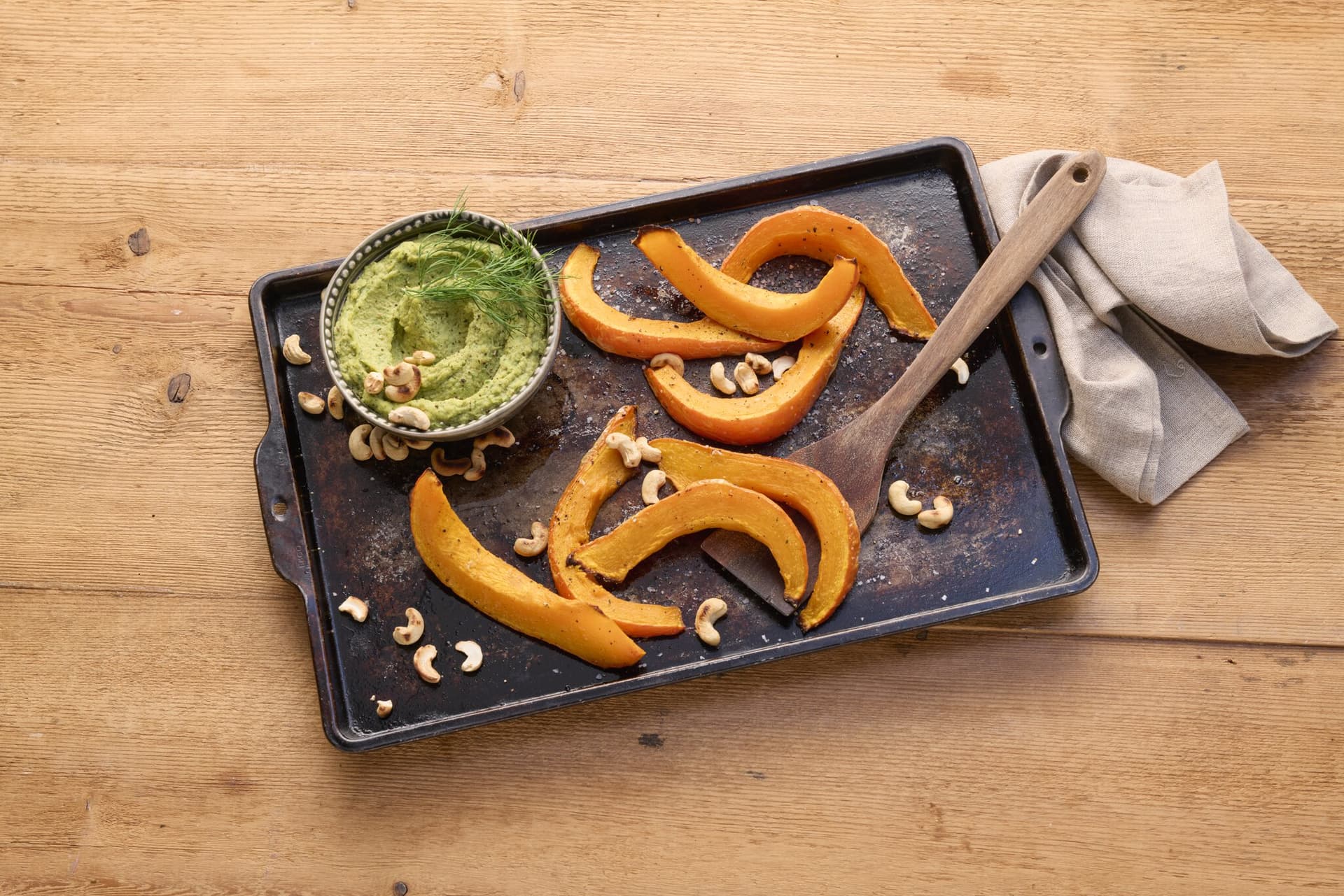 Kräuter-Hummus mit Ofen-Kürbisspalten und crunchy Cashews