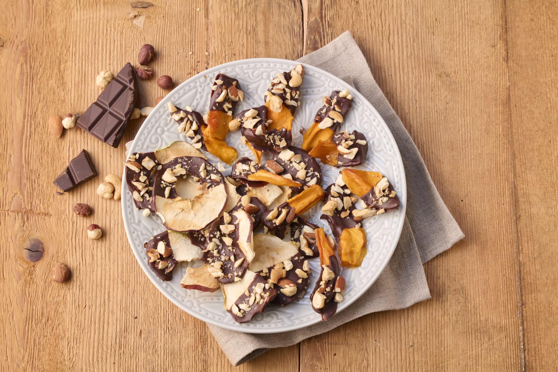 Mango- und Apfelchips in Schokolade mit Nuss