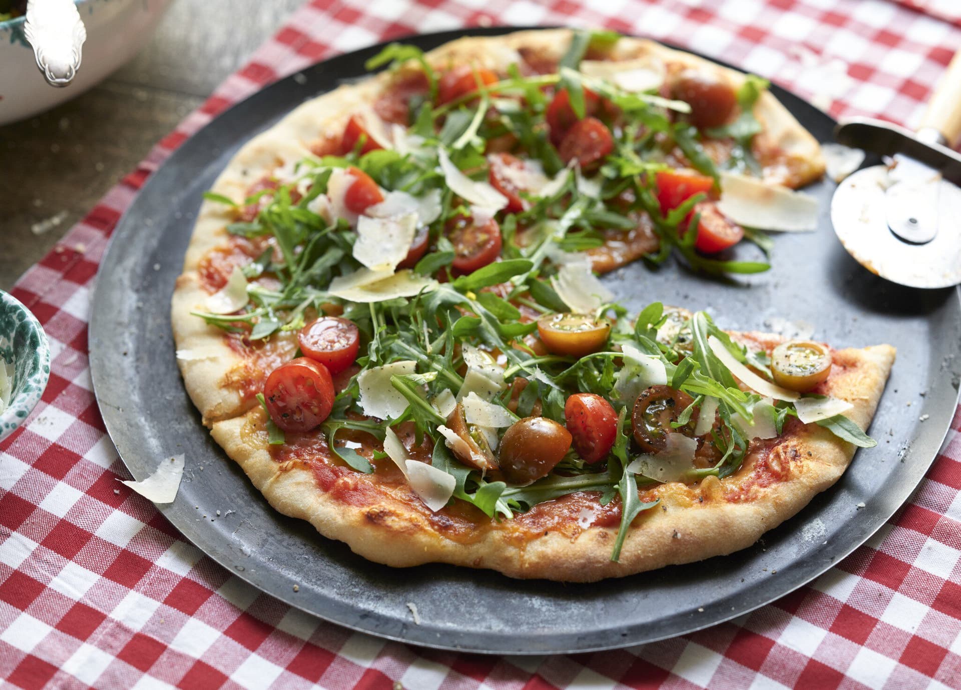 Pizza mit Rucola und Tomaten