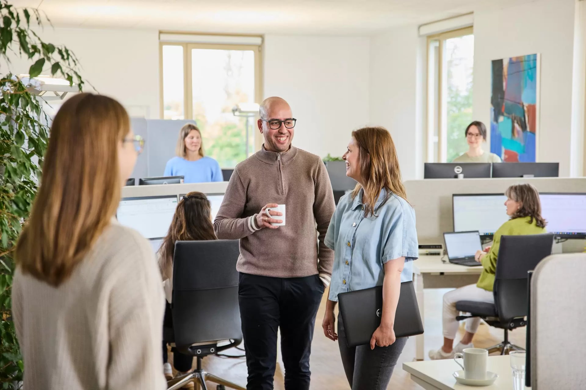 Mitarbeiterinnen und Mitarbeiter in den Büroräumen beim Arbeiten