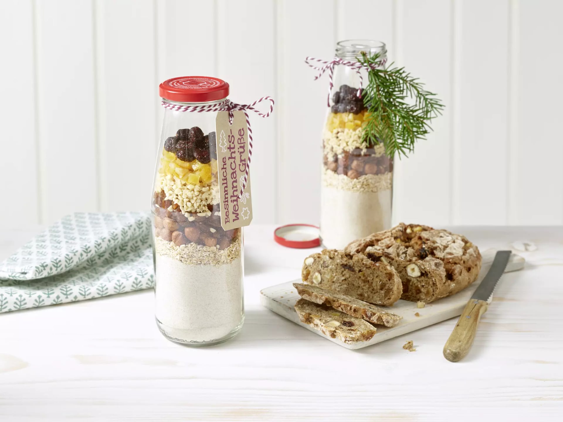 Früchtebrot-Zutaten, geschichtet in Glasflaschen.