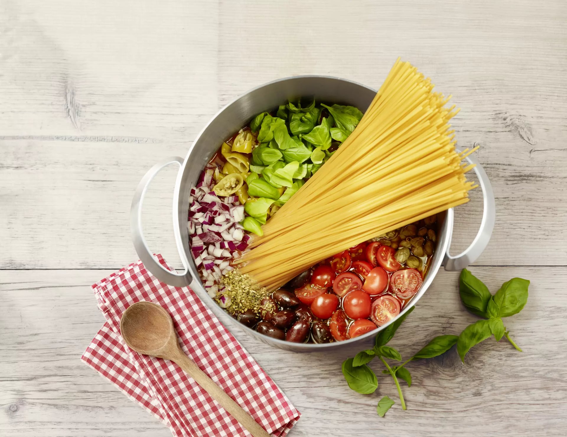 Spaghetti, Tomaten, Zwiebel, Basilikum und Gewürze zusammen in einen Topf mit Wasser.