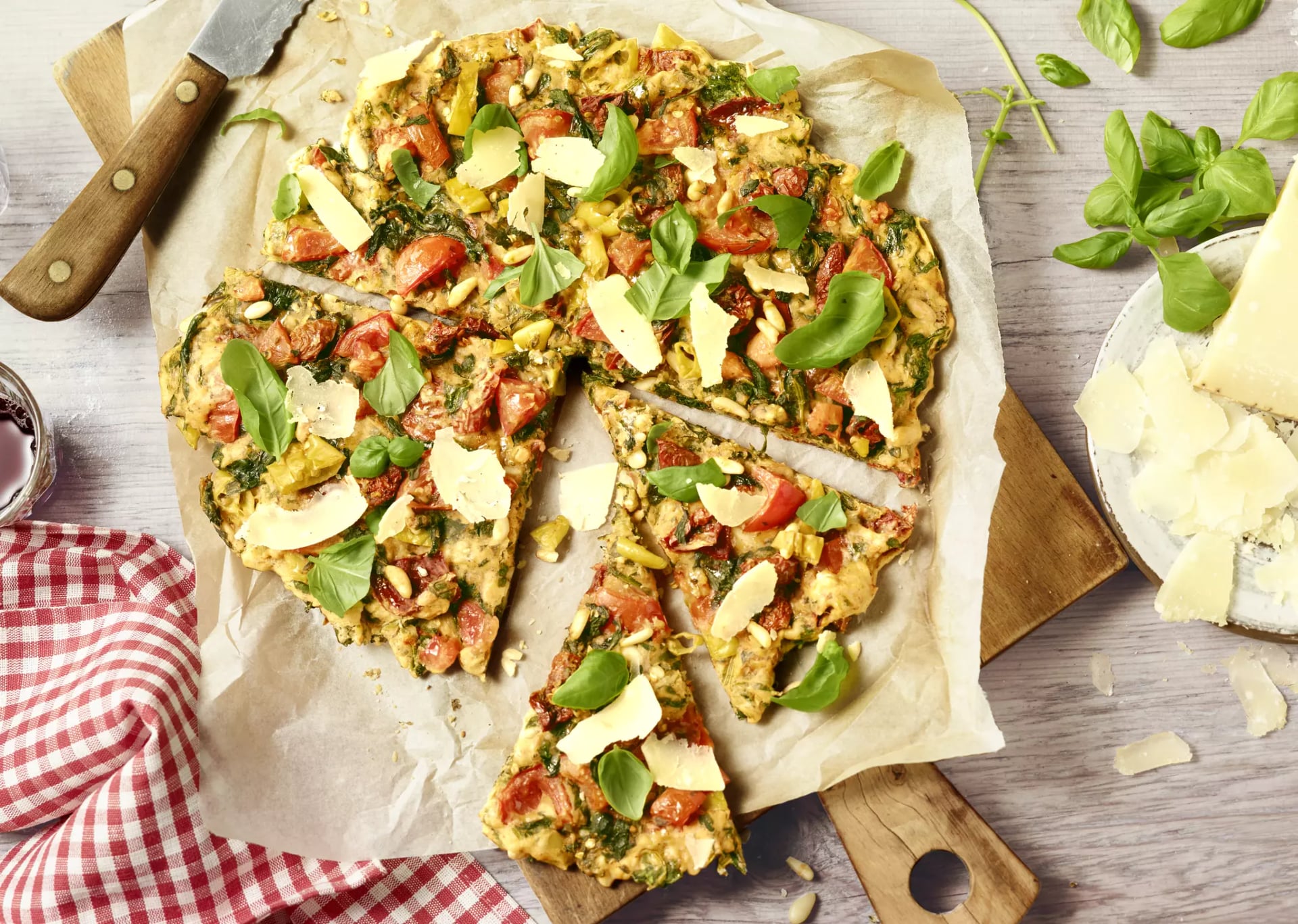 Fertige Pizza auf Holzbrett in Stücke geteilt.