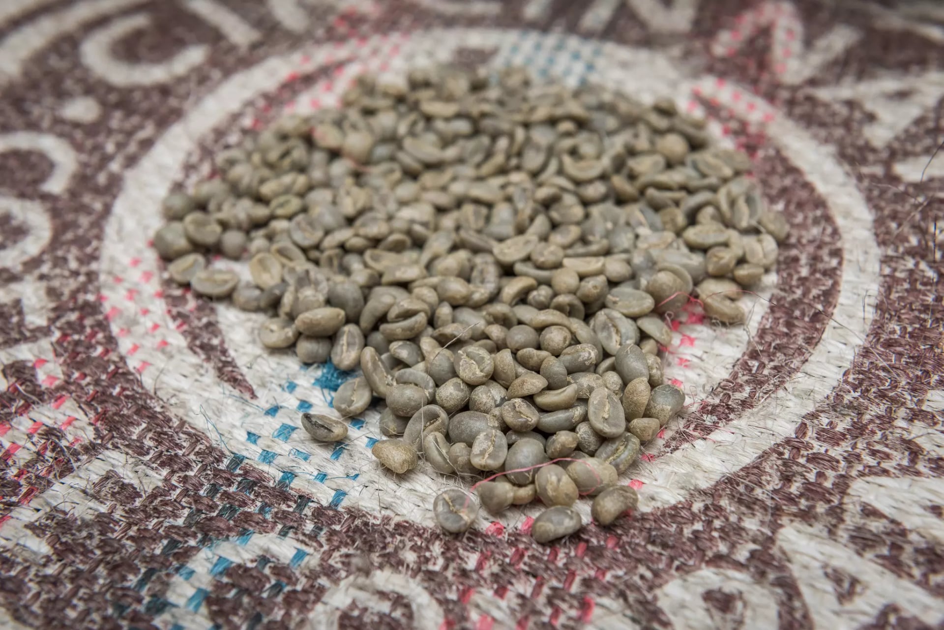 Ungeröstete Kaffeebohnen auf einem Kaffeesack.