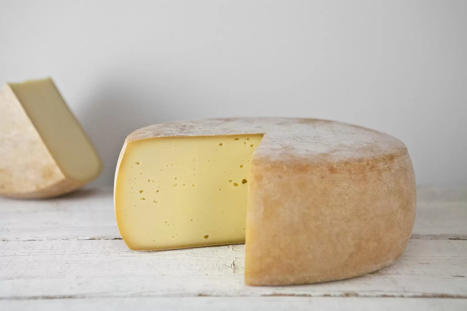 Ein angeschnittener Schnittkäse liegt auf einem Tisch