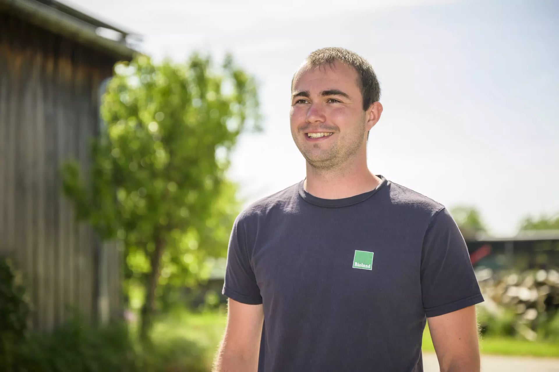 Portrait des Landwirtes der Erzeugergemeinschaft BESH. Im Hintergrund verschwommen Teile des Hofes.