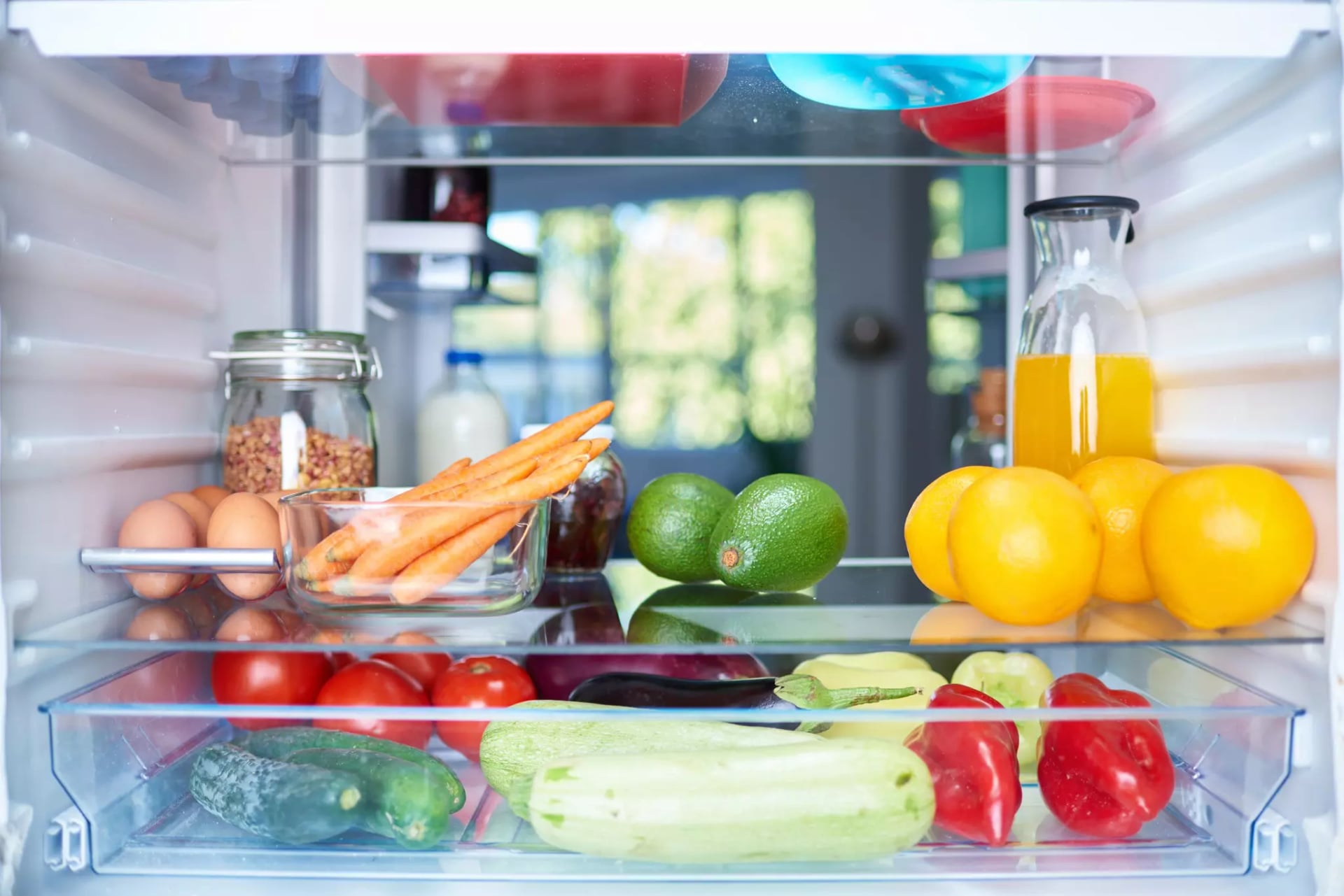 Ein geöffneter Kühlschrank mit Obst, Gemüse und Eiern.