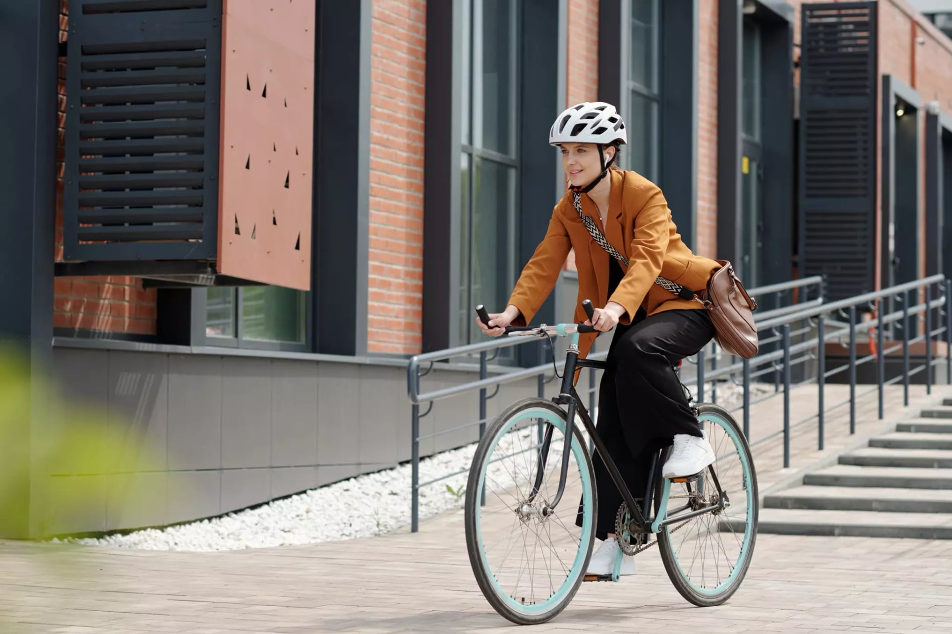 Eine junge Frau fährt auf einem Fahrrad durch die Stadt und trägt dabei einen Helm