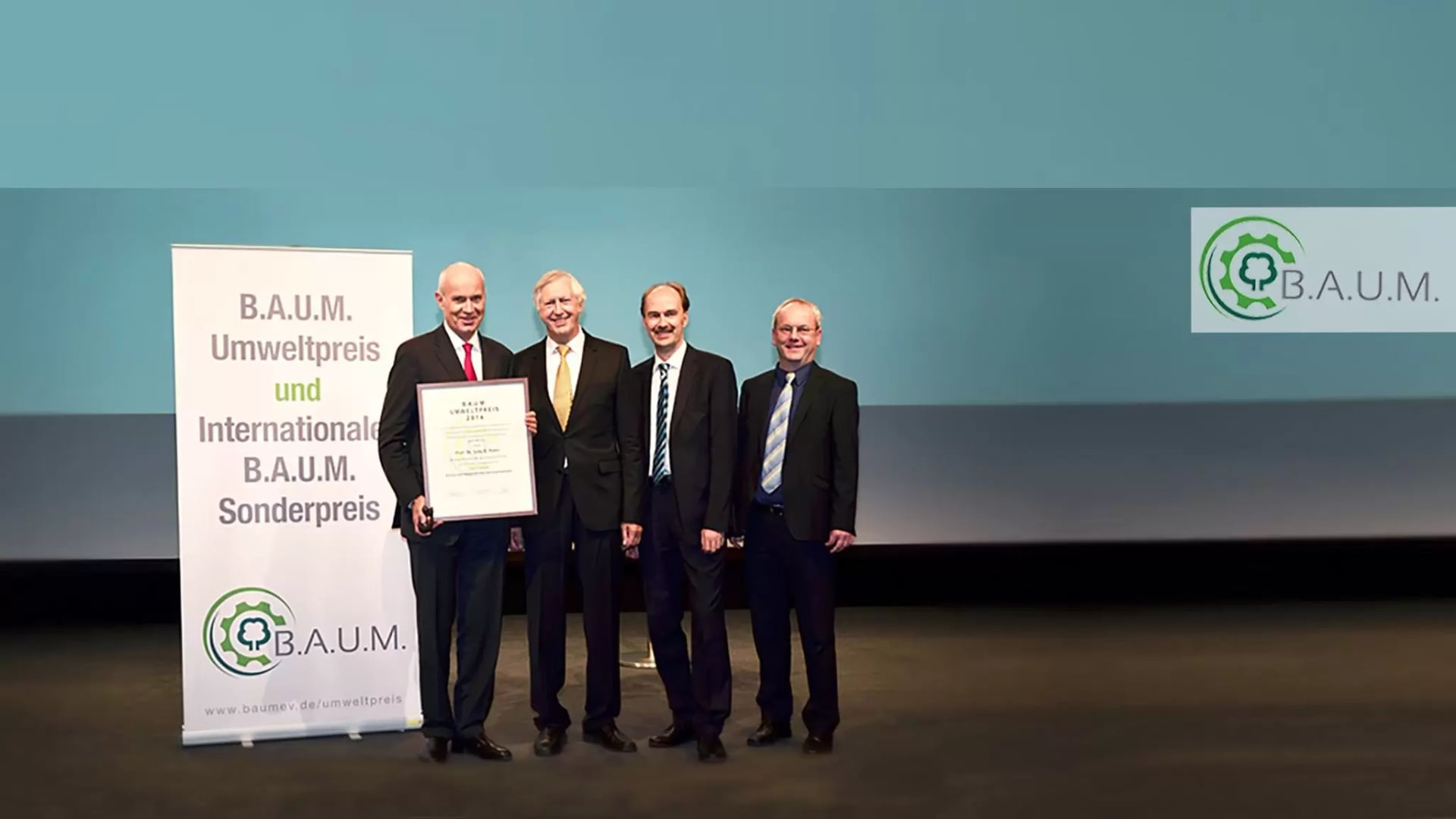 Preisträger des B.A.U.M. Umwelltpreis und Sonderpreis hält sein Zertifikat in die Kamera
