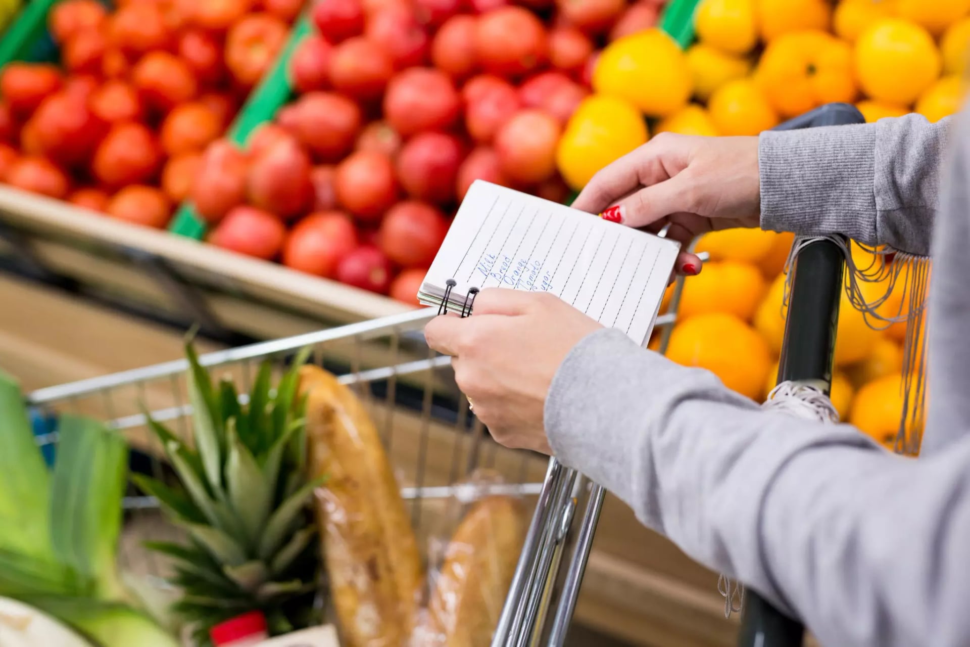 Frau mit Einkaufsliste im Supermarkt.